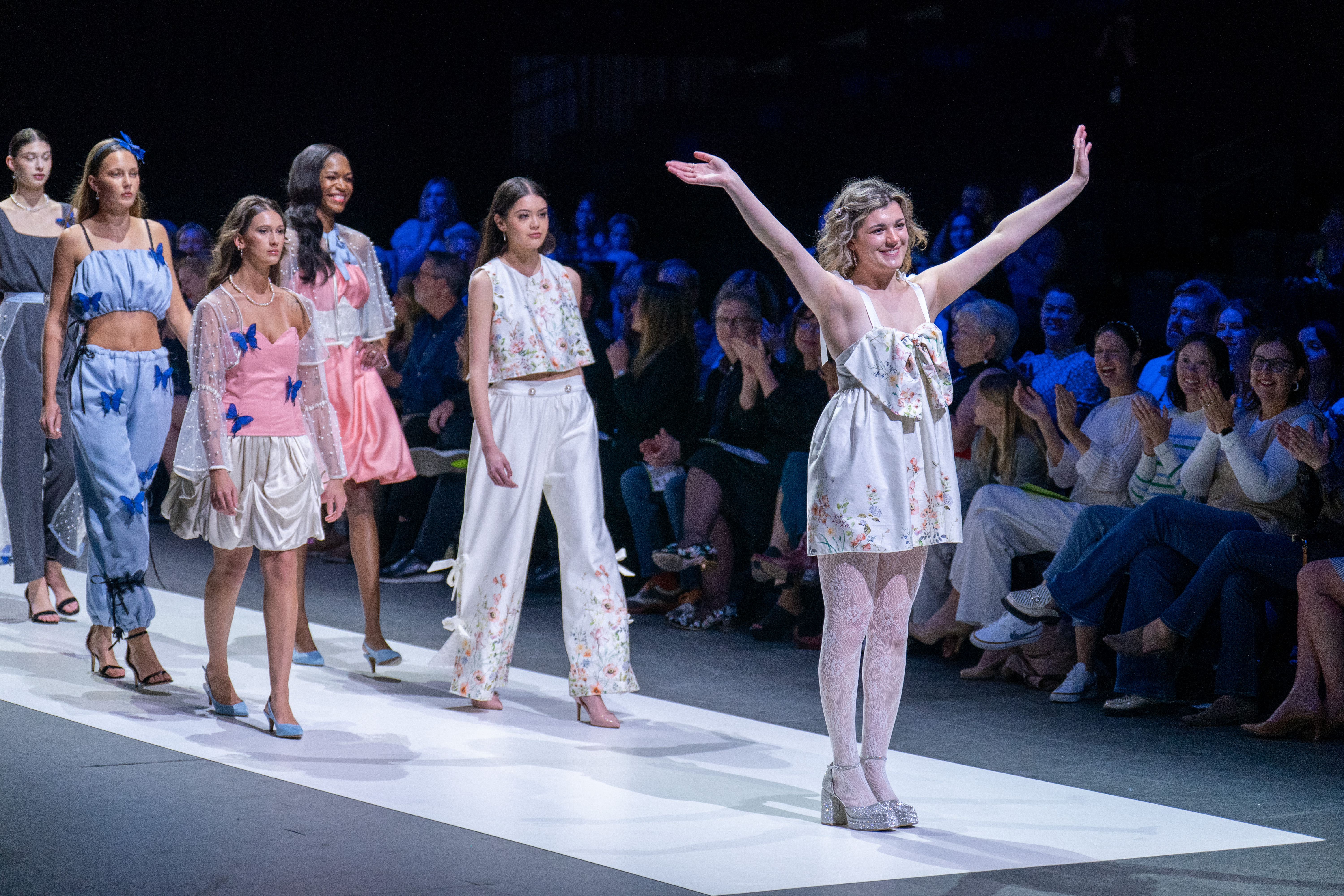 Models and designer showing a floral/pink/white/blue collection