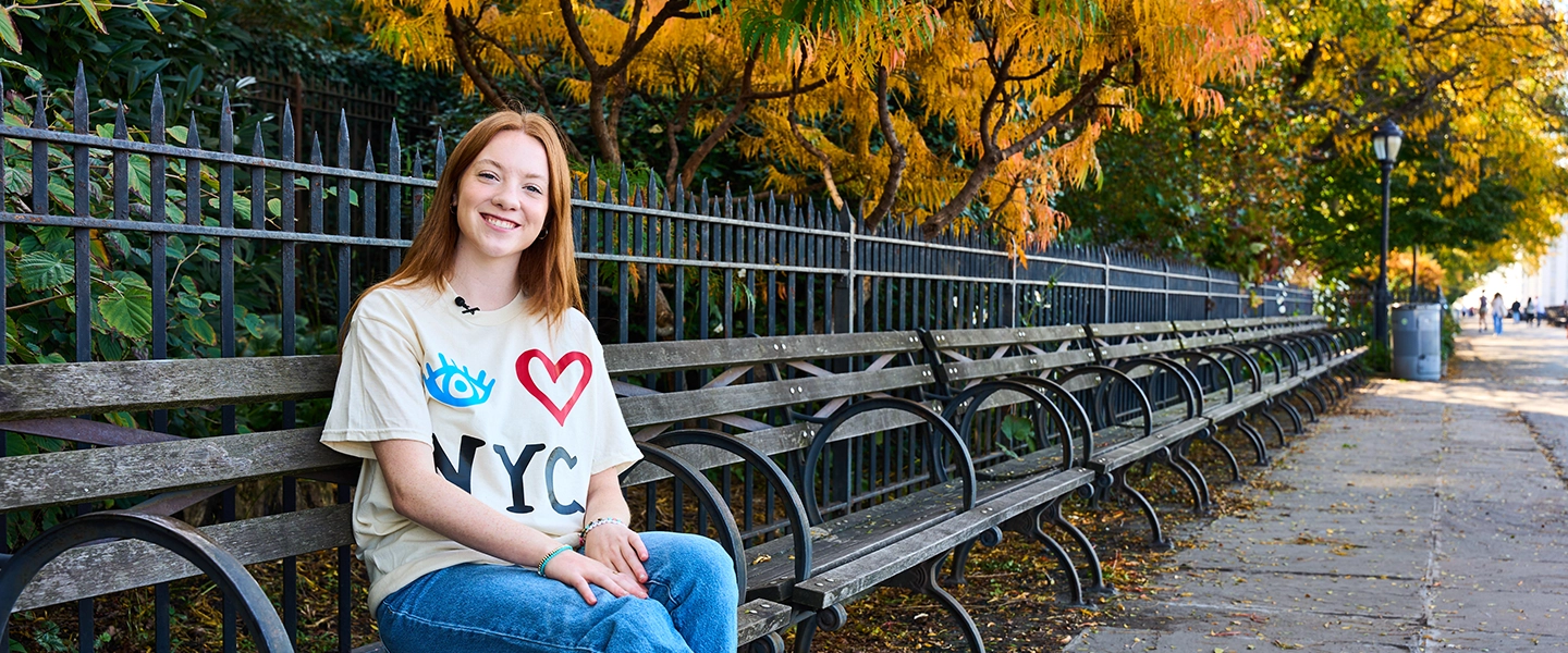 A Belmont USA student sitting on a bench in New York with an I heart NYC t-shirt