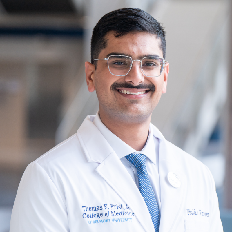 Ubaid Tanveer, medical student at Belmont University's Thomas F. Frist, Jr. College of Medicine, smiling in a lab coat.