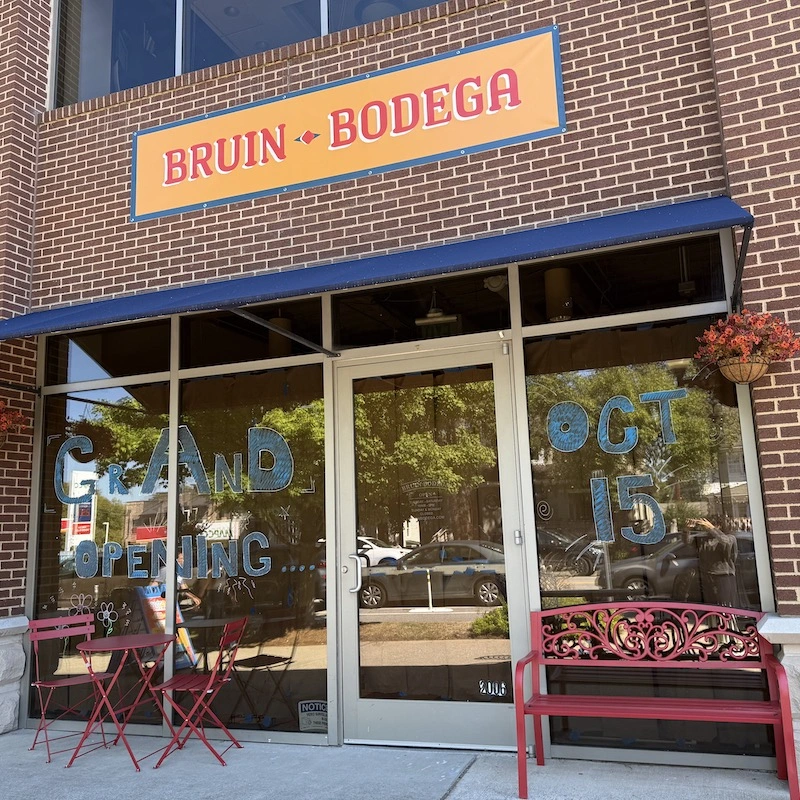 The entrance to Bruin Bodega, a storefront with a brick facade featuring a sign above the door. The windows display colorful lettering announcing the "GRAND OPENING" on October 15. A small red bench and two red chairs are positioned outside, inviting visitors to sit.The entrance to Bruin Bodega, a storefront with a brick facade featuring a sign above the door. The windows display colorful lettering announcing the "GRAND OPENING" on October 15. A small red bench and two red chairs are positioned outside, inviting visitors to sit.The entrance to Bruin Bodega, a storefront with a brick facade featuring a sign above the door. The windows display colorful lettering announcing the "GRAND OPENING" on October 15. A small red bench and two red chairs are positioned outside, inviting visitors to sit.The entrance to Bruin Bodega, a storefront with a brick facade featuring a sign above the door. The windows display colorful lettering announcing the "GRAND OPENING" on October 15. A small red bench and two red chairs are positioned outside, inviting visitors to sit.The entrance to Bruin Bodega, a storefront with a brick facade featuring a sign above the door. The windows display colorful lettering announcing the "GRAND OPENING" on October 15. A small red bench and two red chairs are positioned outside, inviting visitors to sit.The entrance to Bruin Bodega, a storefront with a brick facade featuring a sign above the door. The windows display colorful lettering announcing the "GRAND OPENING" on October 15. A small red bench and two red chairs are positioned outside, inviting visitors to sit.The entrance to Bruin Bodega, a storefront with a brick facade featuring a sign above the door. The windows display colorful lettering announcing the "GRAND OPENING" on October 15. A small red bench and two red chairs are positioned outside, inviting visitors to sit.The entrance to Bruin Bodega, a storefront with a brick facade featuring a sign above the door. The windows display colorful lettering announcing the "GRAND OPENING" on October 15. A small red bench and two red chairs are positioned outside, inviting visitors to sit.The entrance to Bruin Bodega, a storefront with a brick facade featuring a sign above the door. The windows display colorful lettering announcing the "GRAND OPENING" on October 15. A small red bench and two red chairs are positioned outside, inviting visitors to sit.The entrance to Bruin Bodega, a storefront with a brick facade featuring a sign above the door. The windows display colorful lettering announcing the "GRAND OPENING" on October 15. A small red bench and two red chairs are positioned outside, inviting visitors to sit.The entrance to Bruin Bodega, a storefront with a brick facade featuring a sign above the door. The windows display colorful lettering announcing the "GRAND OPENING" on October 15. A small red bench and two red chairs are positioned outside, inviting visitors to sit.The entrance to Bruin Bodega, a storefront with a brick facade featuring a sign above the door. The windows display colorful lettering announcing the "GRAND OPENING" on October 15. A small red bench and two red chairs are positioned outside, inviting visitors to sit.The entrance to Bruin Bodega, a storefront with a brick facade featuring a sign above the door. The windows display colorful lettering announcing the "GRAND OPENING" on October 15. A small red bench and two red chairs are positioned outside, inviting visitors to sit.The entrance to Bruin Bodega, a storefront with a brick facade featuring a sign above the door. The windows display colorful lettering announcing the "GRAND OPENING" on October 15. A small red bench and two red chairs are positioned outside, inviting visitors to sit.