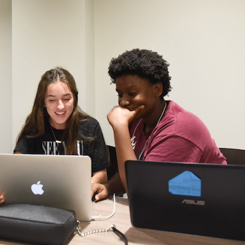 two students looking at a computer screen