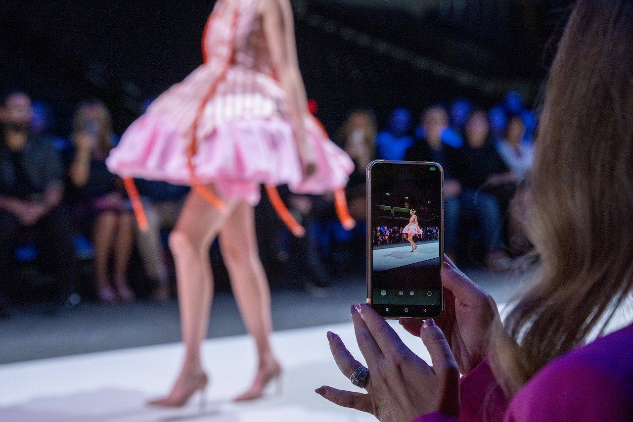 Image of cell phone taking photo of model at 2024 fashion show