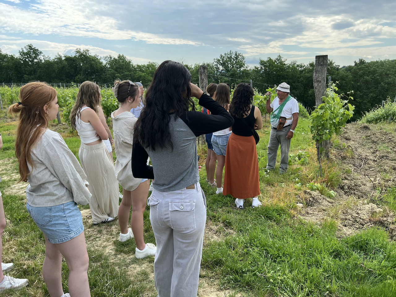 Students in Italy standing listening at a vineyard