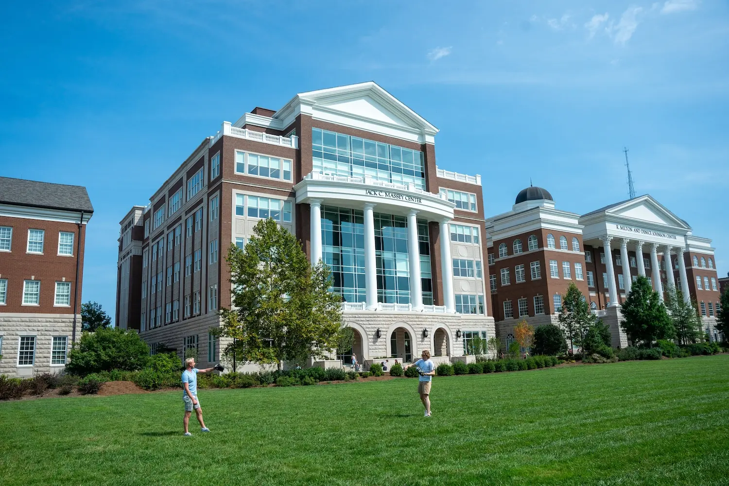 Two Belmont students throwing a football in front of Jack C. Massey Center