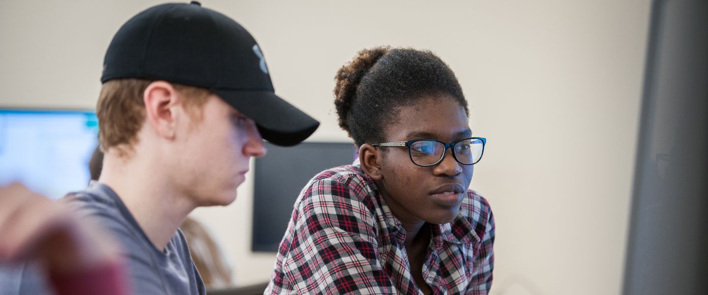 Two computer science students at a computer