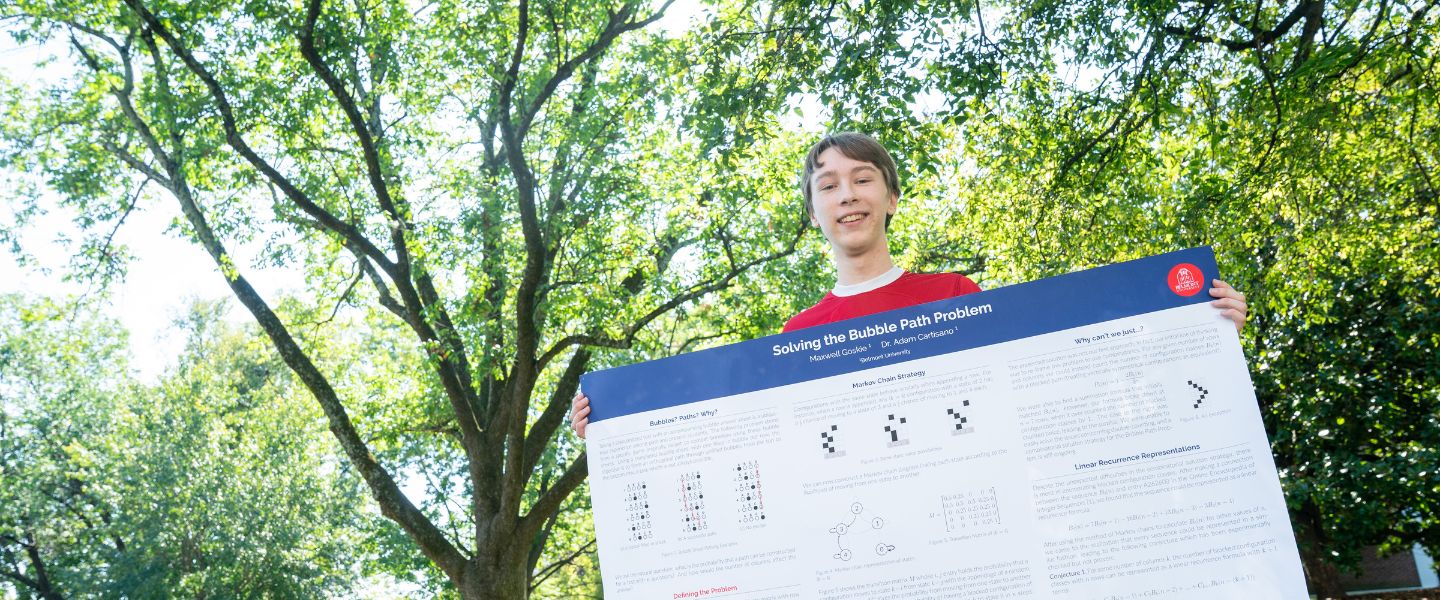 Max Goskie holds up his poster on Belmont's lawn