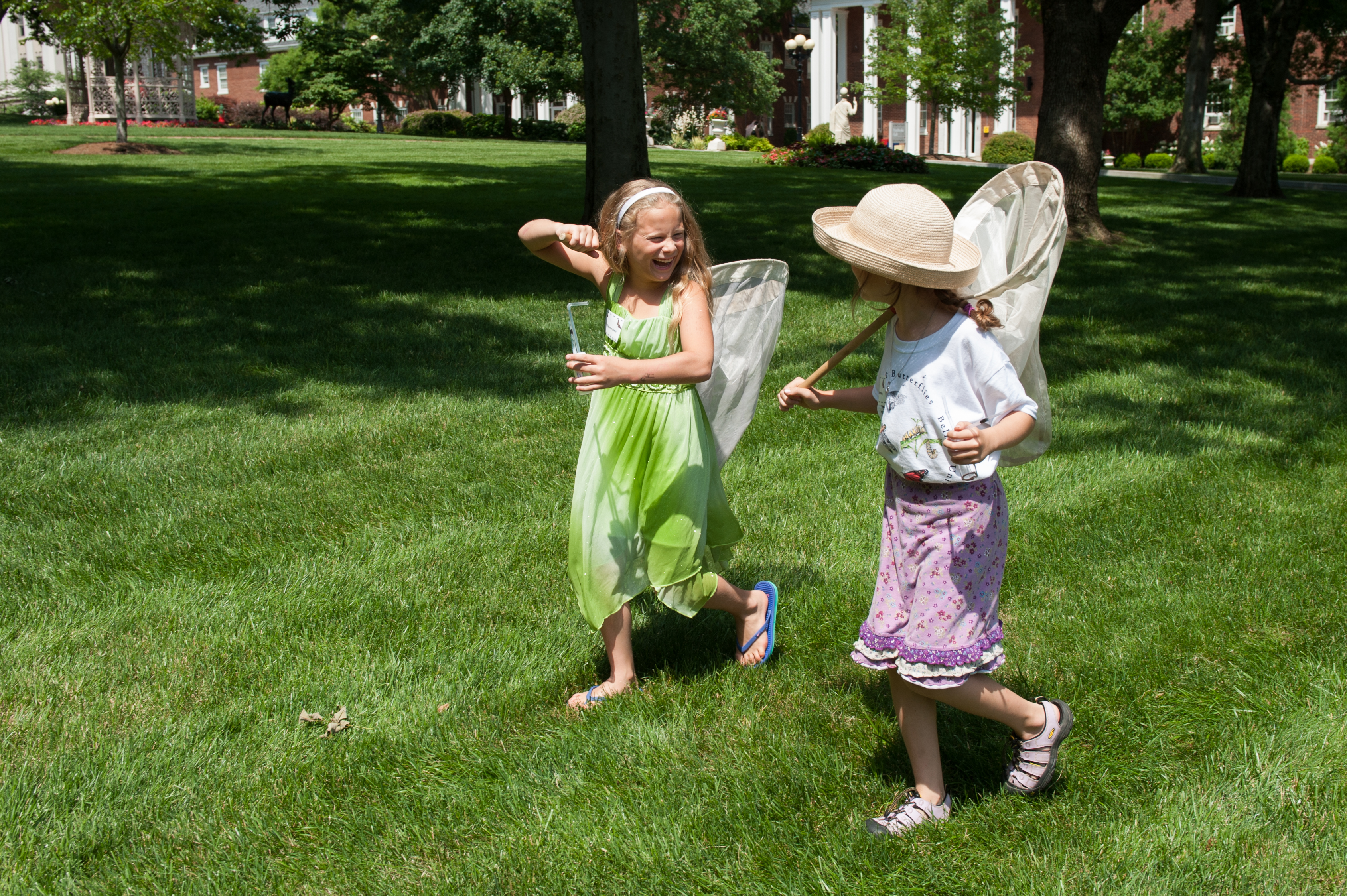 Two campers laugh as they walk with their bug nets