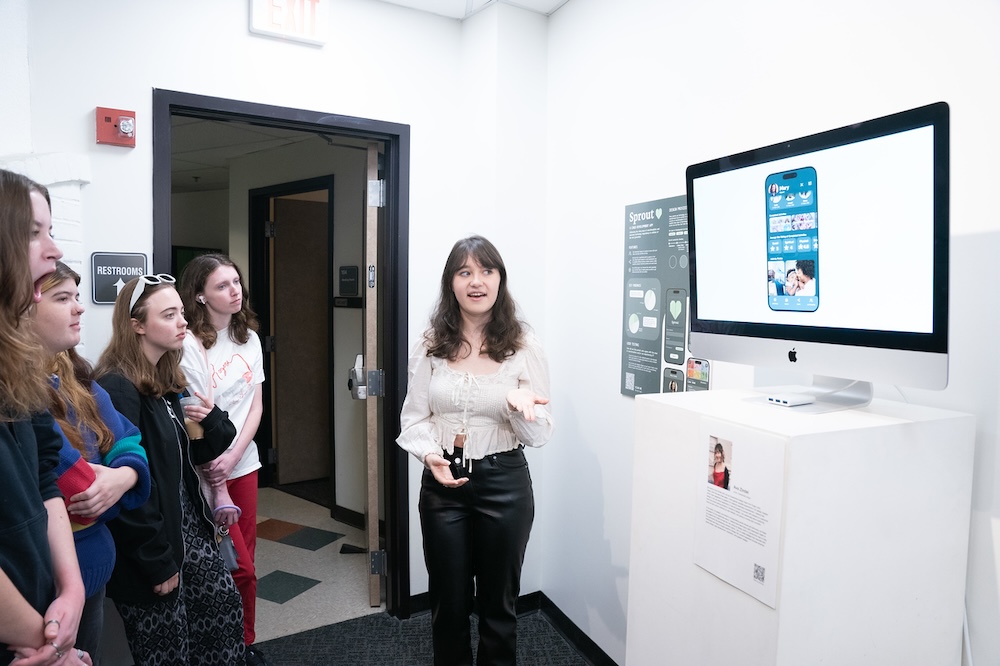 student presenting to other students in gallery