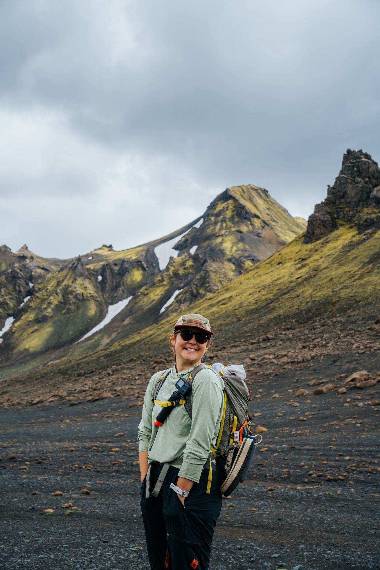 Camille Murashige posed looking back at camera in front of a mountain