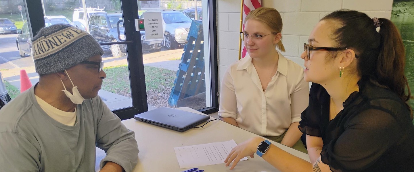  Three law students helping man at clinic