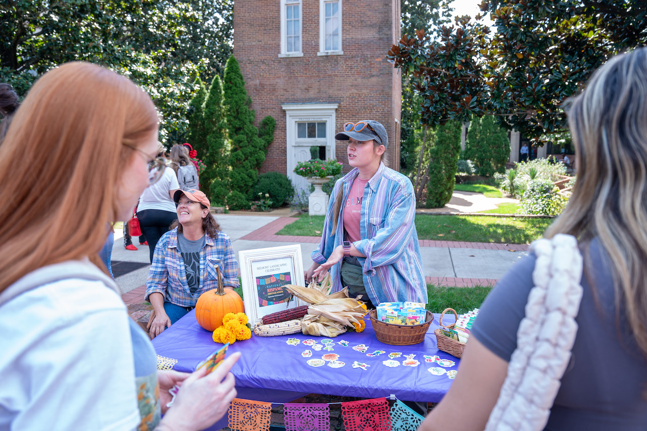 Woman speaking with students at table