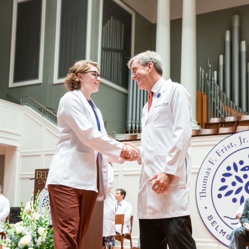 Katie Pursley and Dean Anderson Spickard shake hands at the white coat ceremony