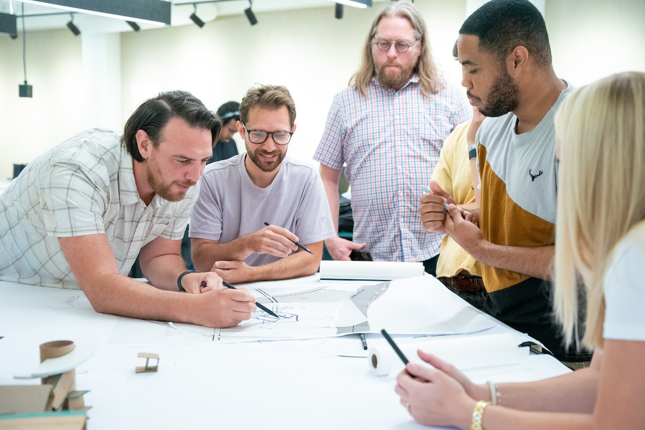 Students and industry professionals looking at student's worl