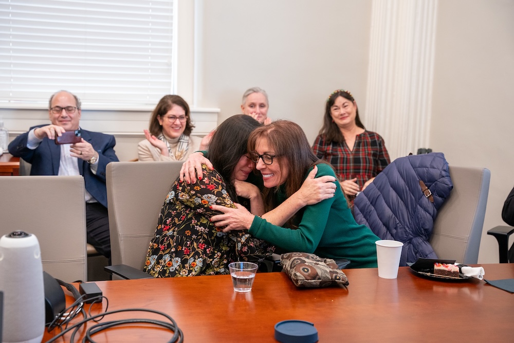 Allen hugs another faculty member when surprise is made