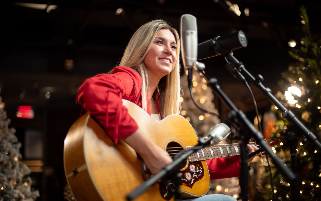 Emmy Moyen sings and plays guitar