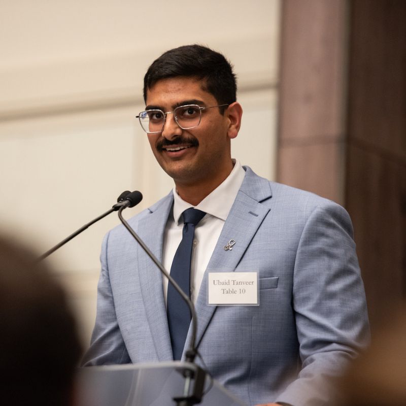 Ubaid Tanveer speaks in front of a microphone