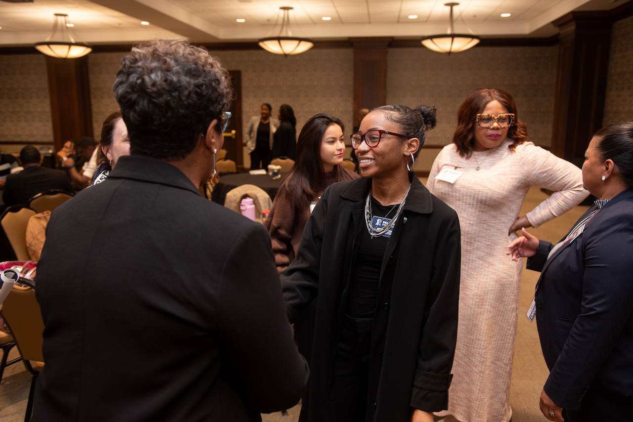 Young woman speaking to woman with back turned