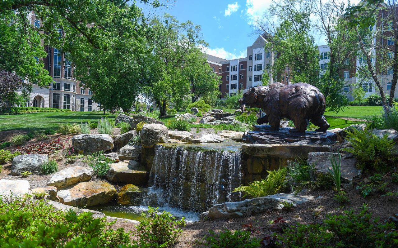 Bear statue and a fountain in front of residence halls as Belmont