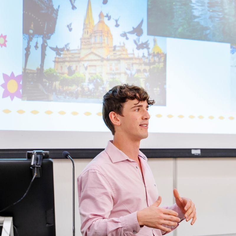 Aaron Kleinschmidt speaks in front of a presentation on Mexico