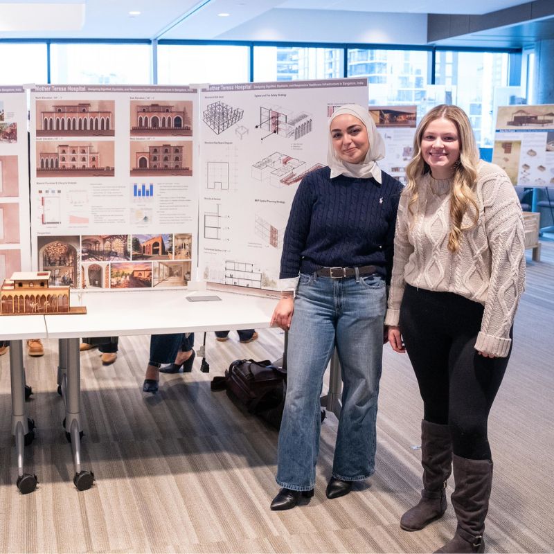 Students pose in front of their designs