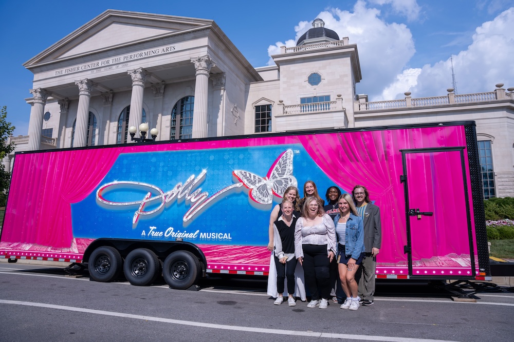 BEST students with Dolly the Musical signage