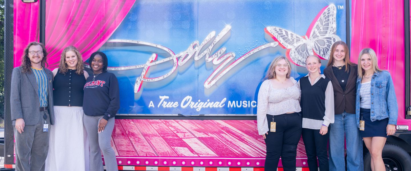 BEST students pose in front of Dolly the Musical signage 
