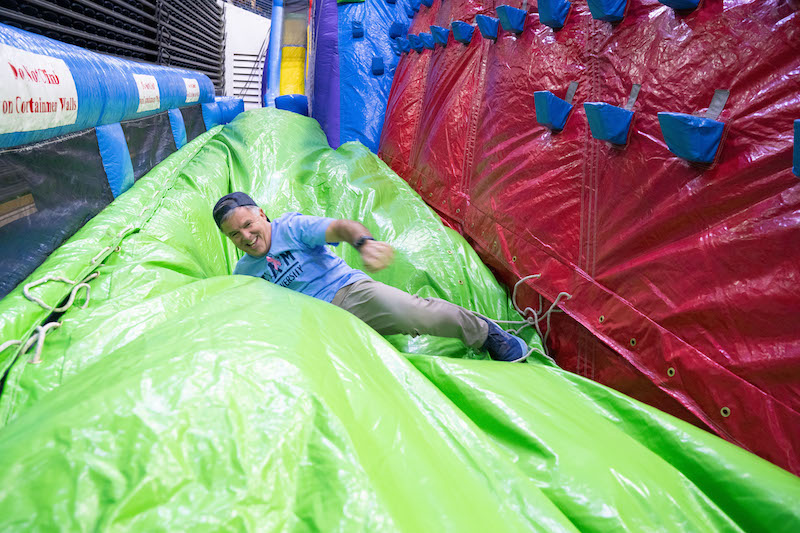Provost sliding down inflatable slide