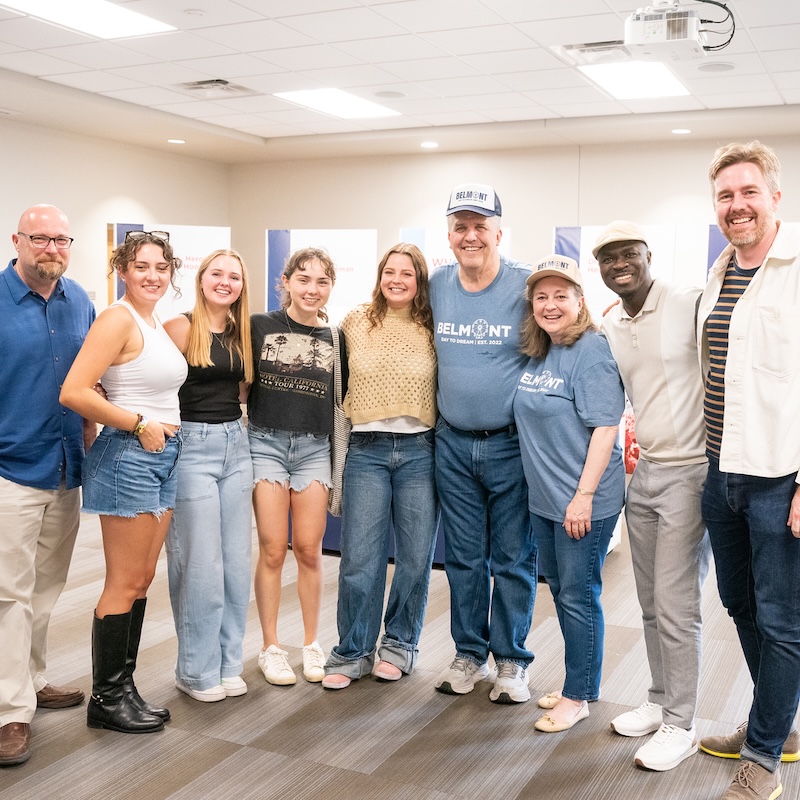 students pose with faculty and the Joneses