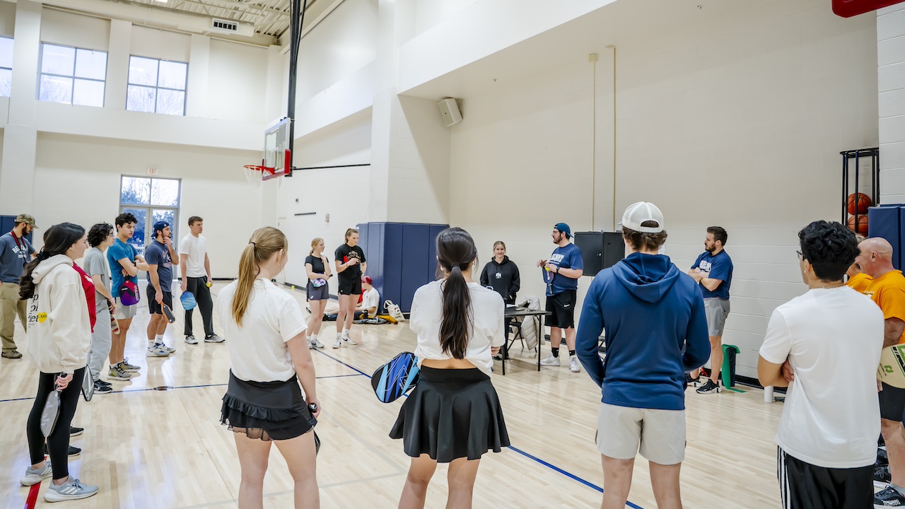 pickleball tournament participants standing in a wide circle