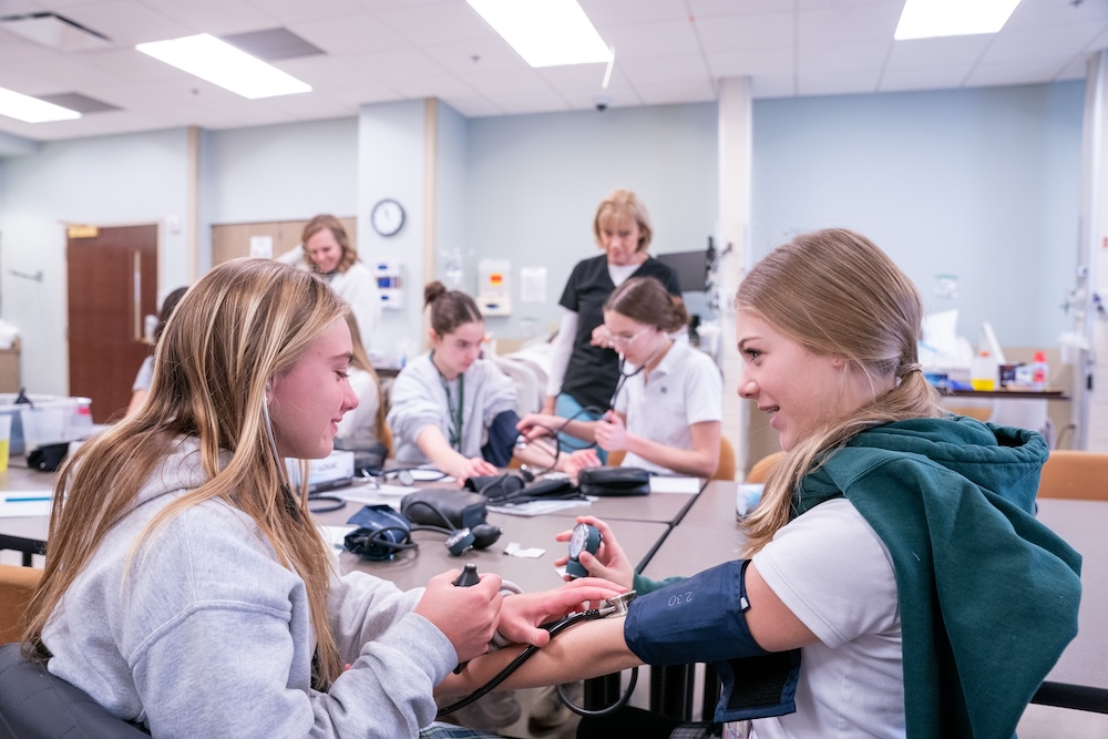 Healthcare 101 students work in simulation lab