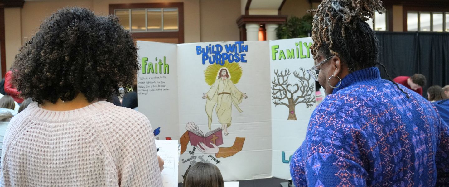 Two women view a project at the What's Your Why Journey Showcase