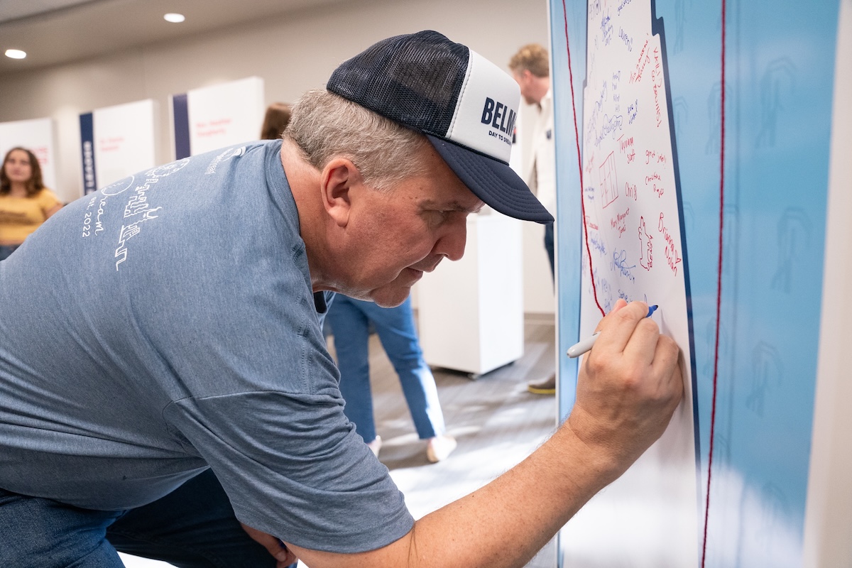 Dr Jones signs name on one of the interactive pieces