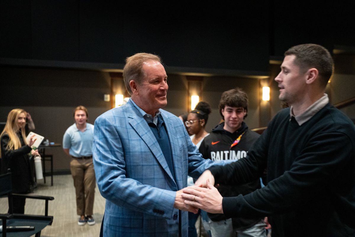 Nantz shaking hands with a male student