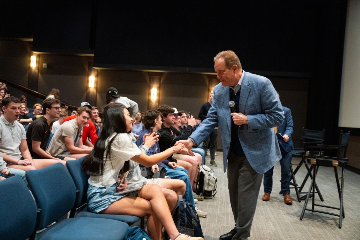 Nantz shaking hands with a female student.