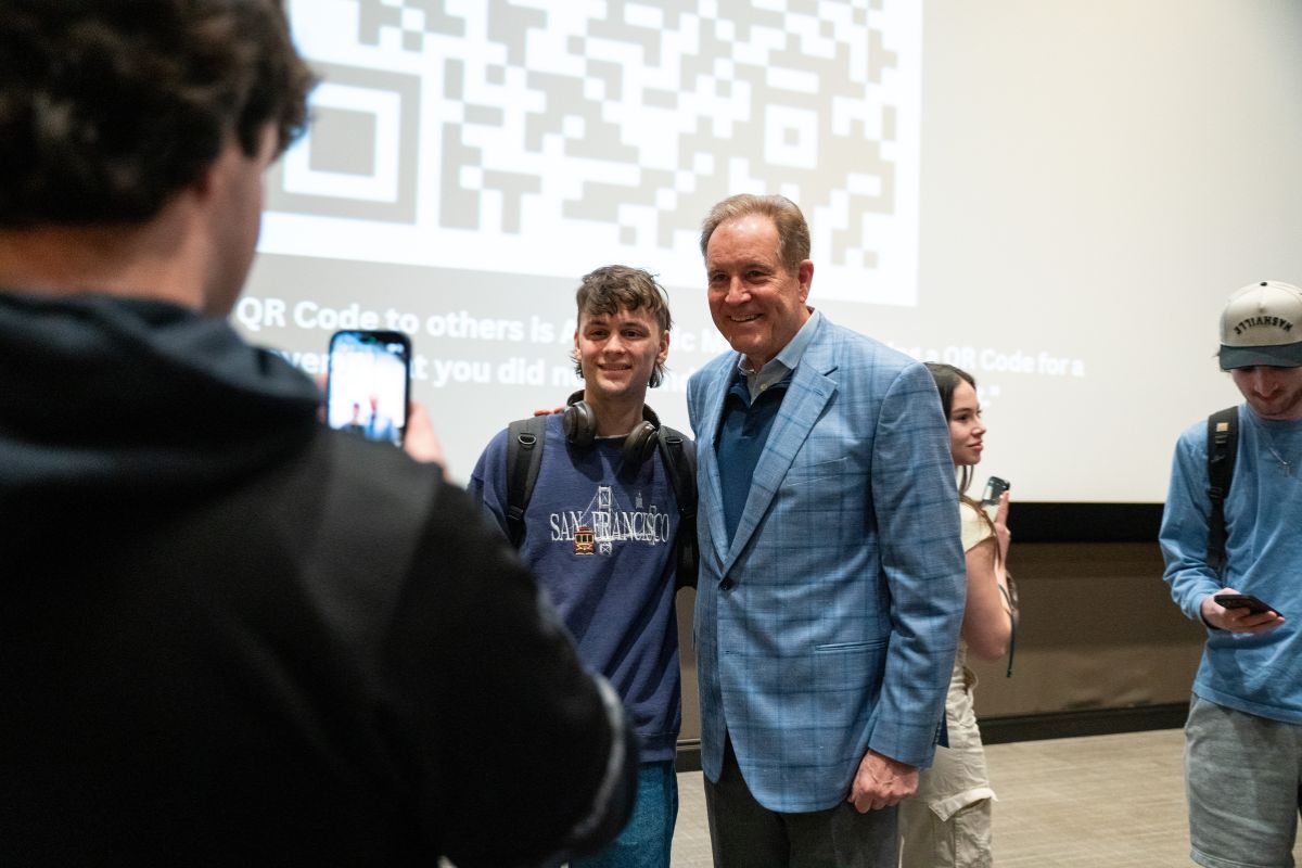 Nantz posing for a photo with a student.