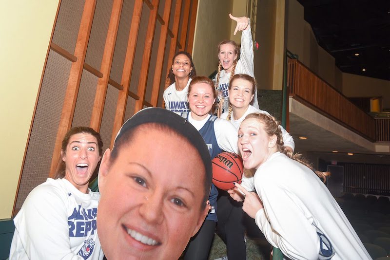 Lauren and teammates on stair with a cut out image