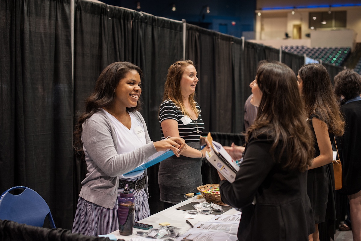 A woman and a student speaking over a table at a networking mixer