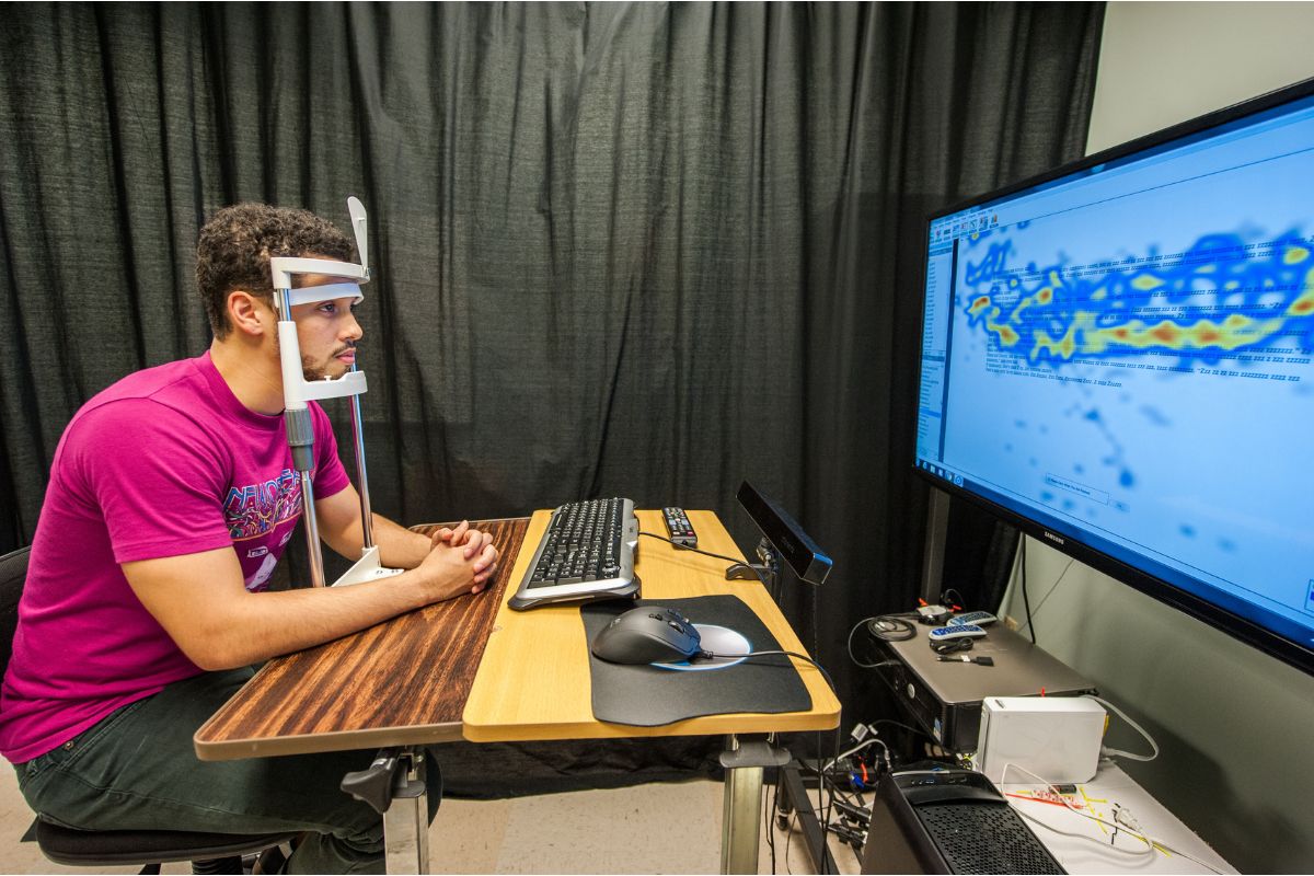 Student measures brain activity with a machine in front of a monitor