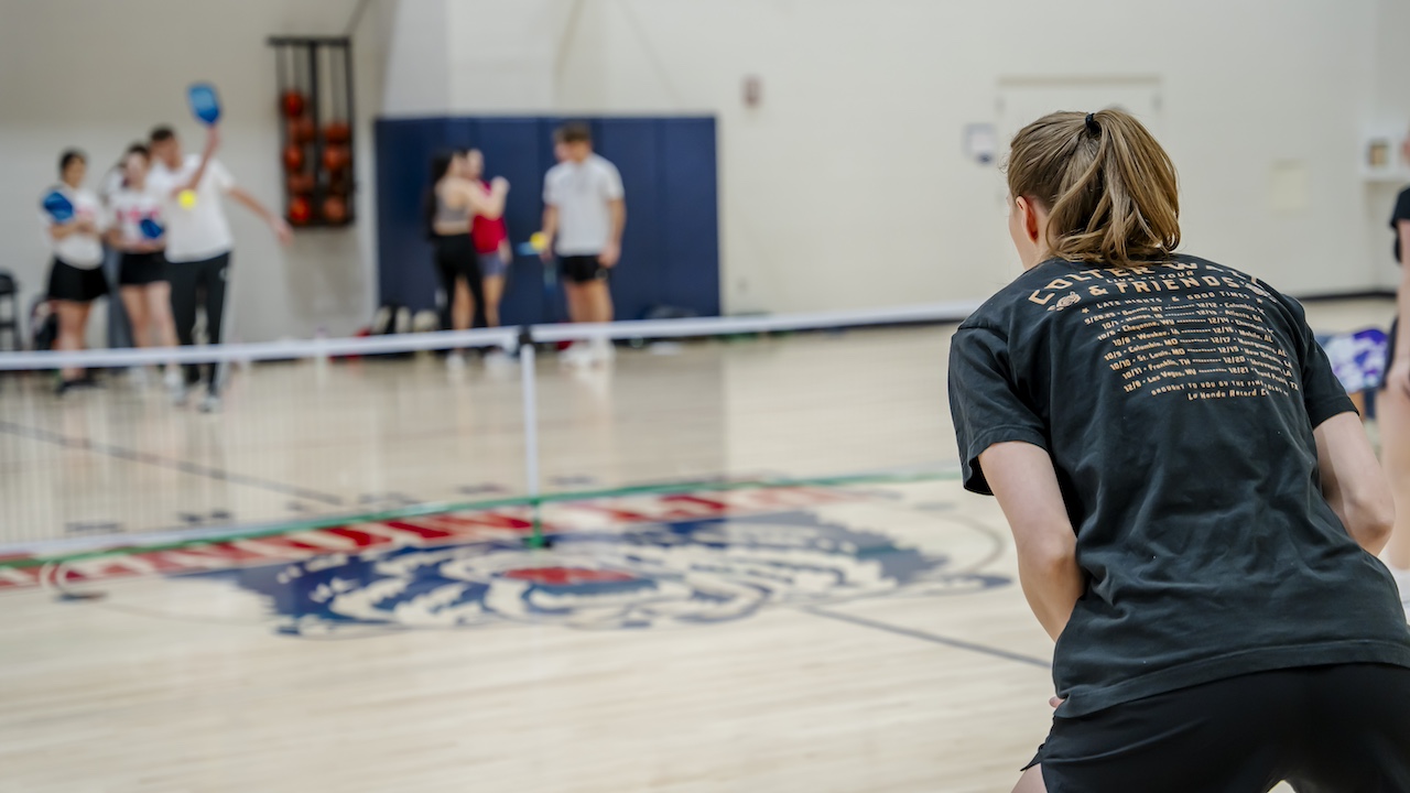 back of student playing pickleball