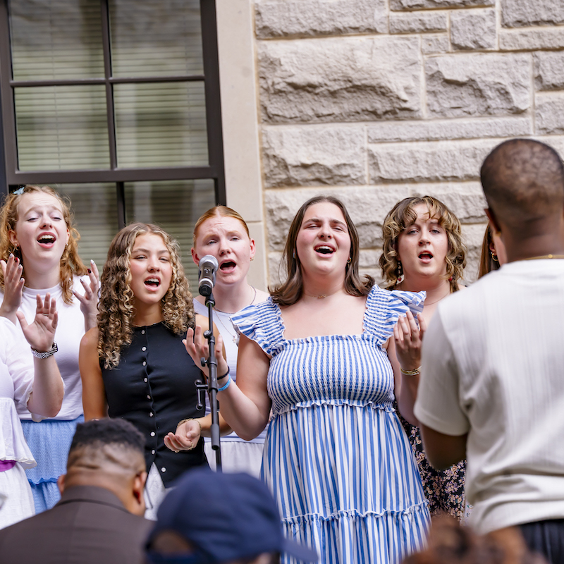 Student in Voxology singing at ceremony