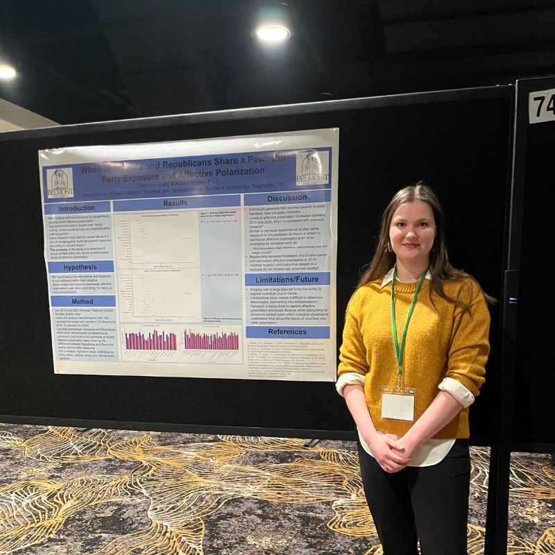 Student poses with her poster