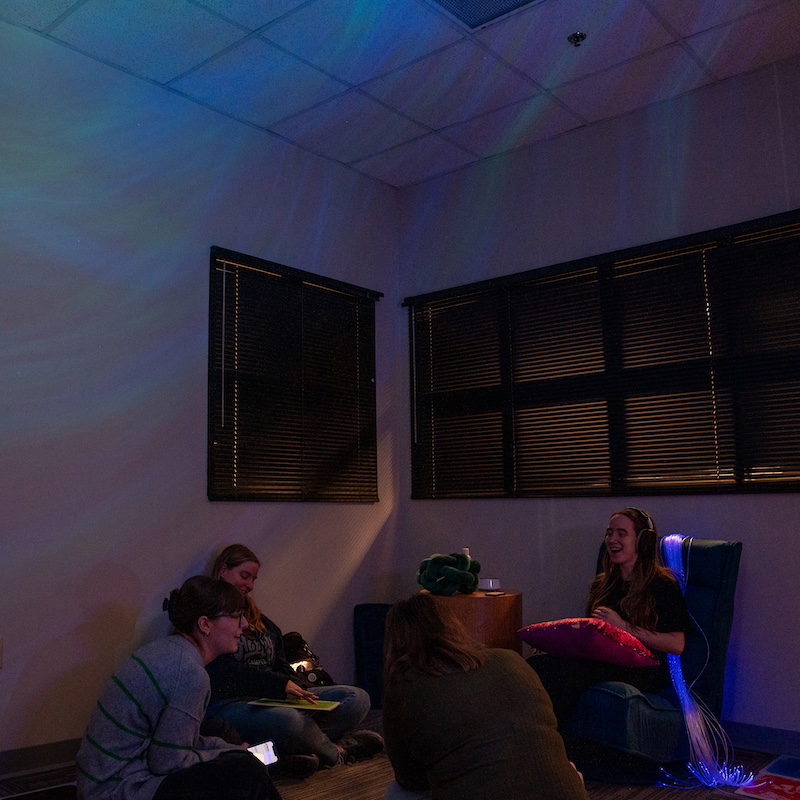 students talking together in a dark room