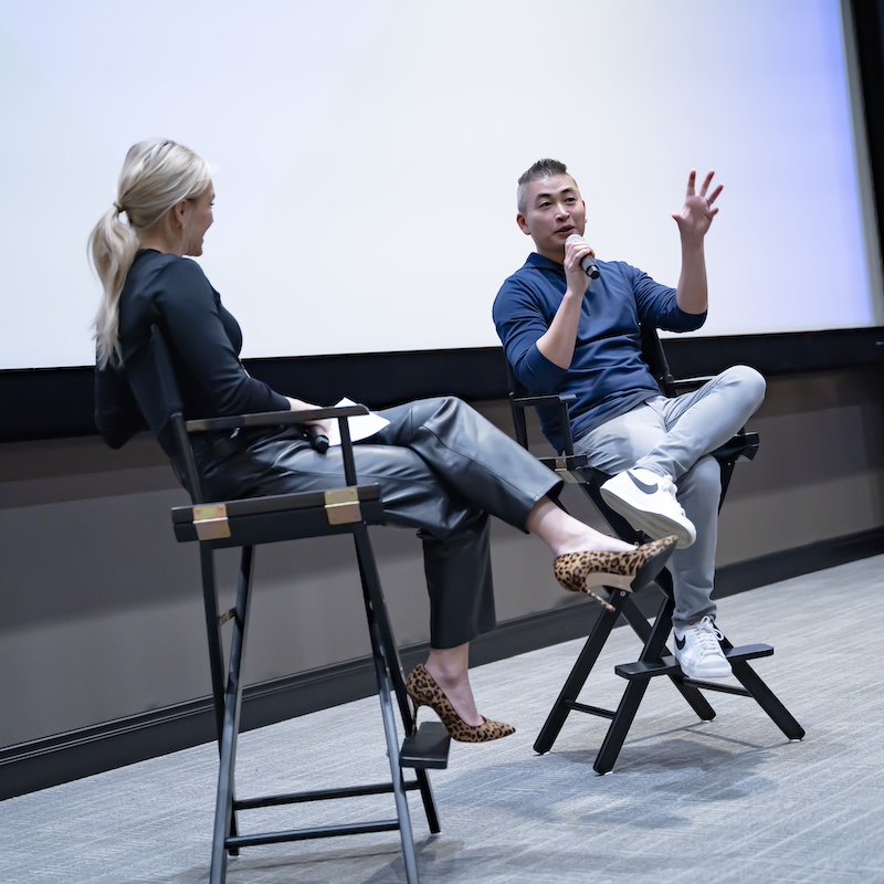 Tracy Chan and Brittany Schaffer speaking in a theater with microphones