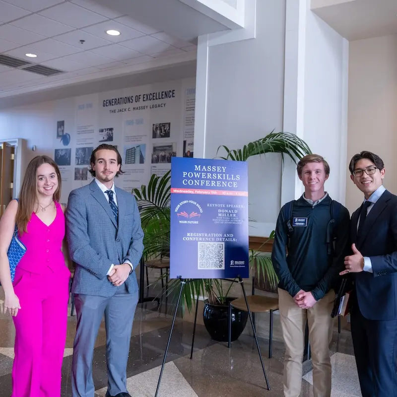 Four student standing inside and smiling around Powerskills conference