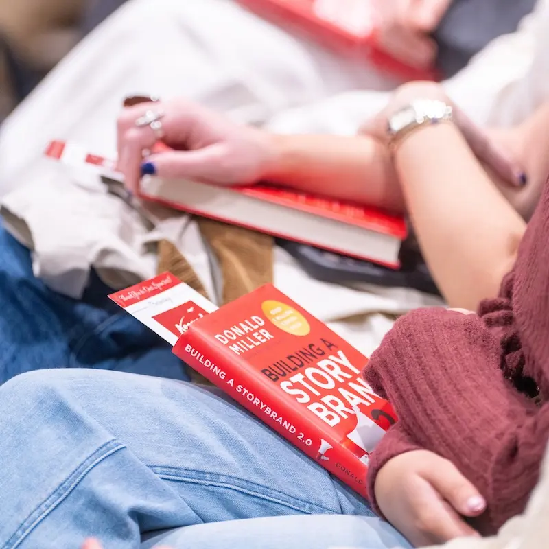 Books of StoryBrand 2.0 on the laps of students