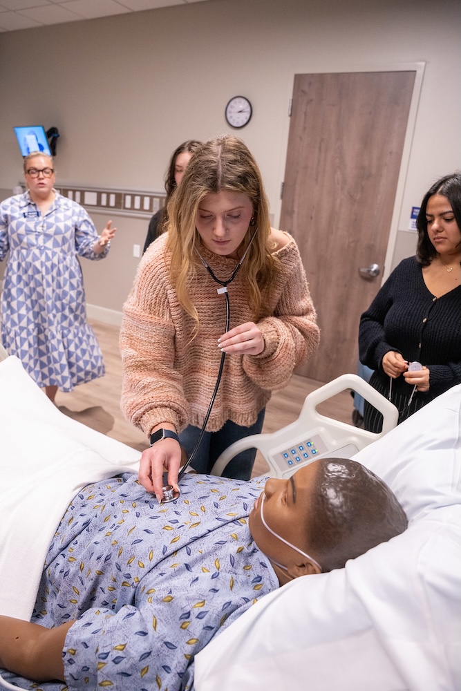 HEALS student practices on a mannequin at orientation