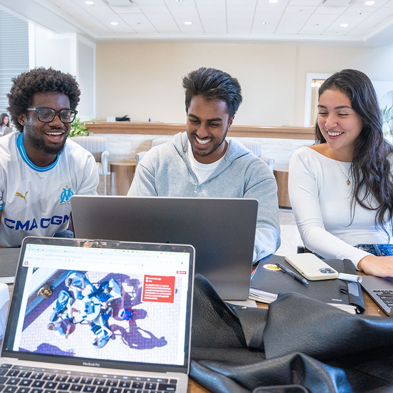 Group of students working on a project at a laptop in the Massey Center