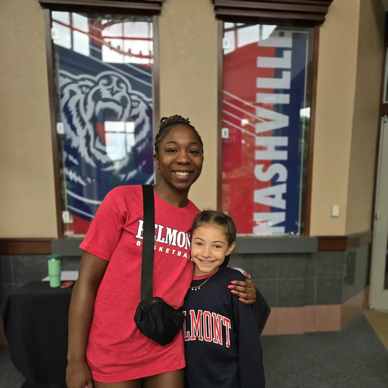 Indoor photo of Hadley posing with a Camp Staffer