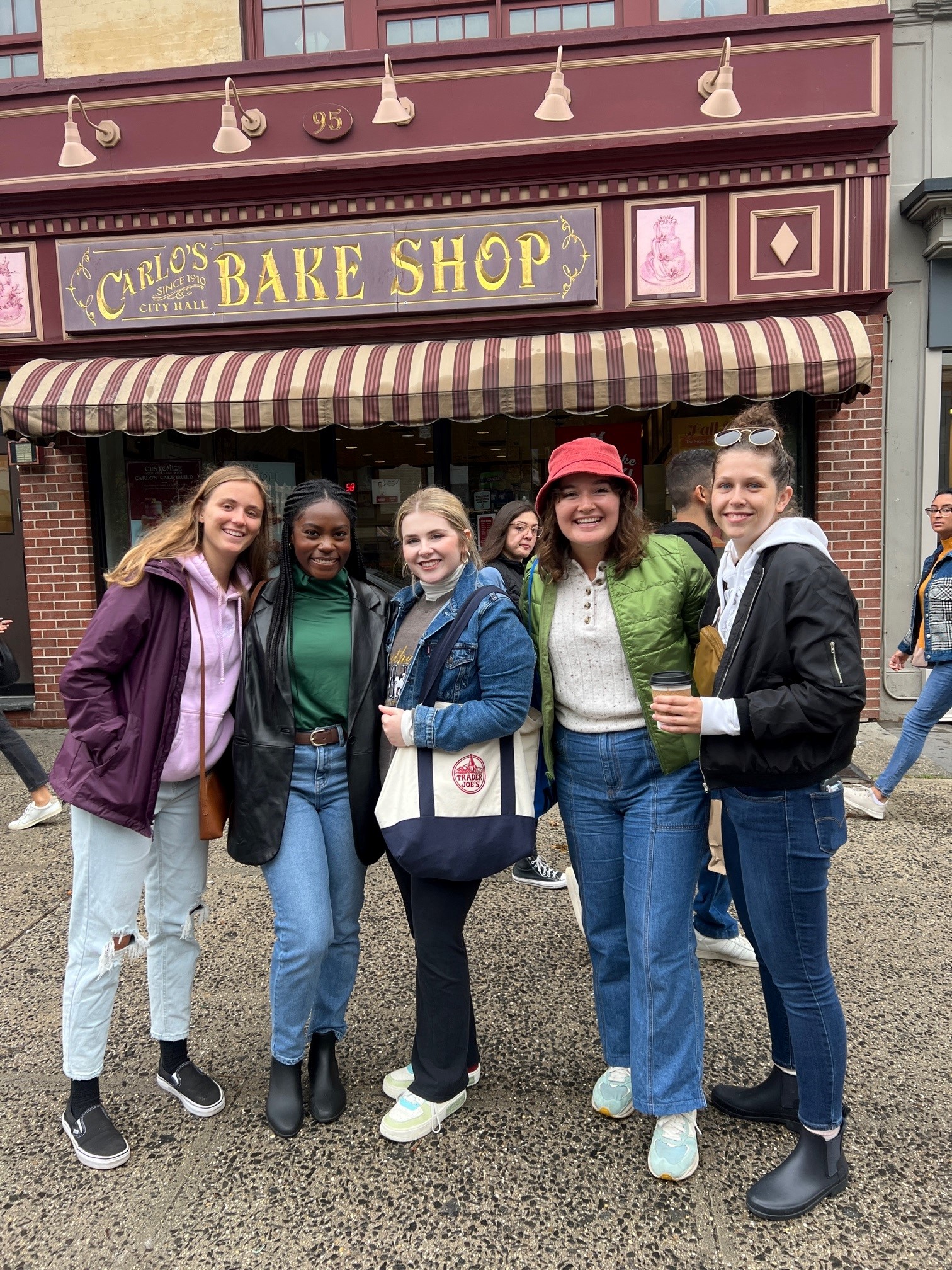 Belmont East students pose for picture in front of Carlo's bake shop