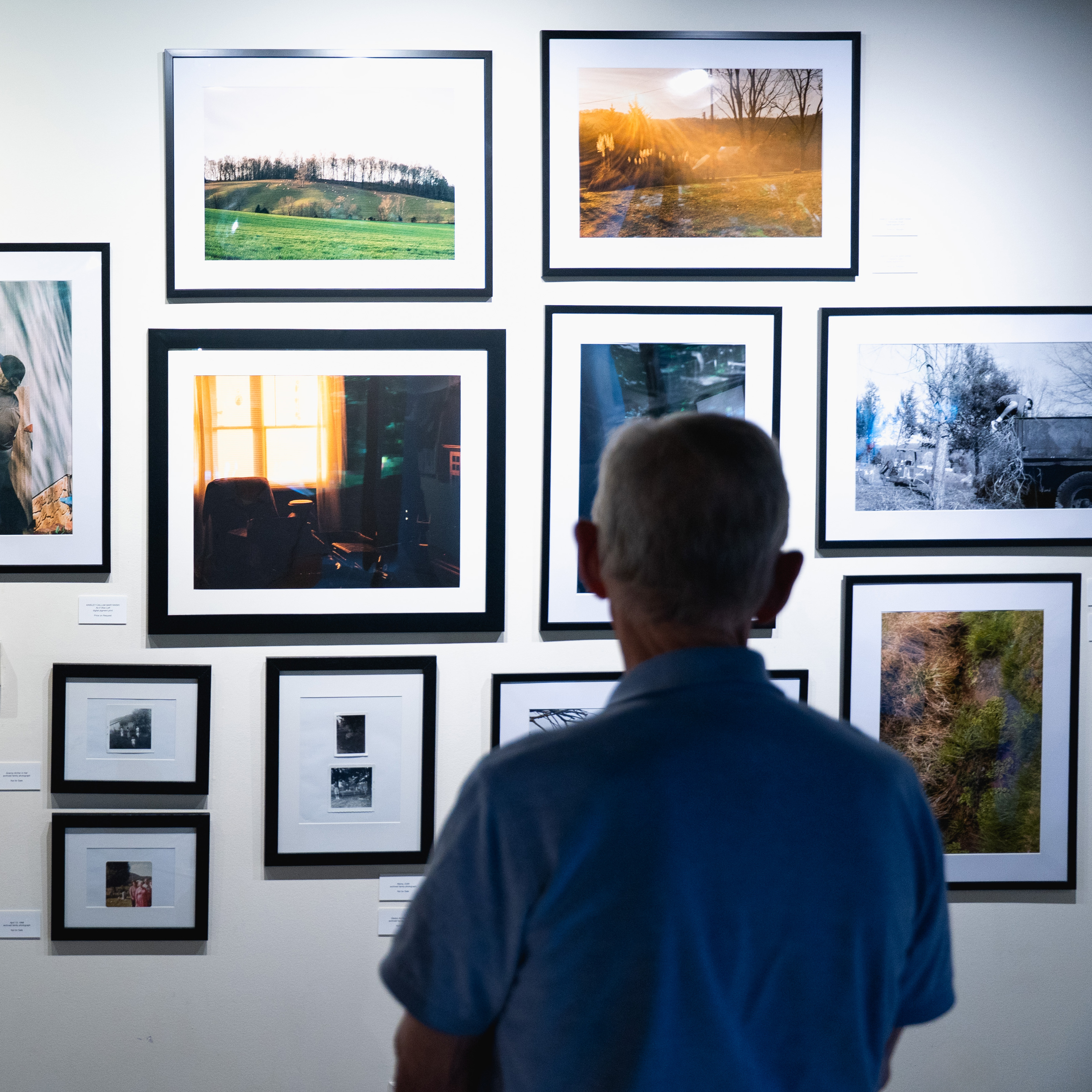 person standing in front of framed photographs